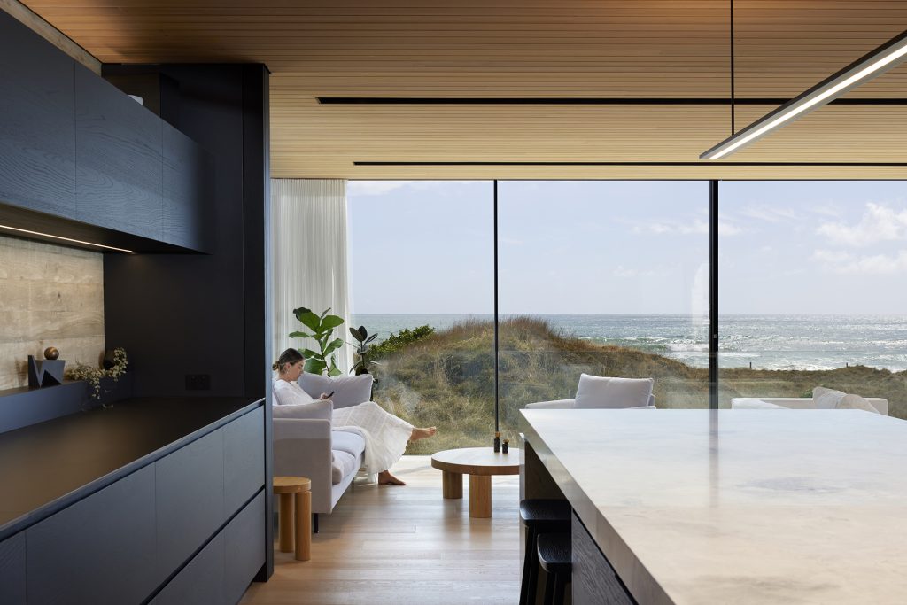 Amanda Aitken Photography work for Brendon Gordon Architects. Image of kitchen and living room overlooking the ocean.