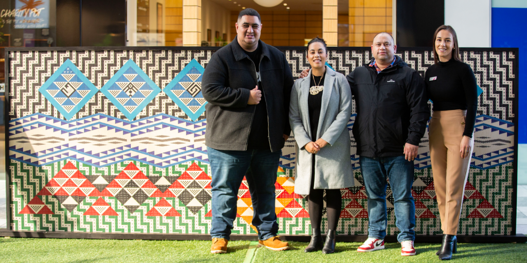 Ira team standing in front of the artwork panels