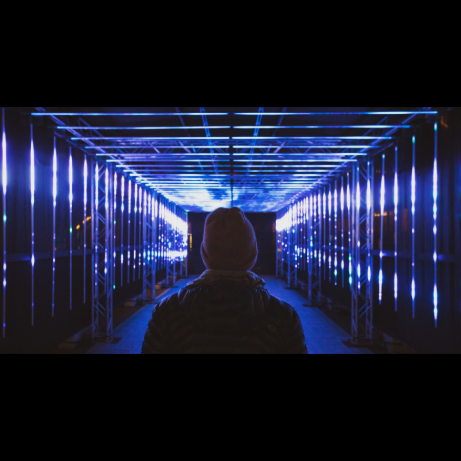 Photo of person walking through light arch way